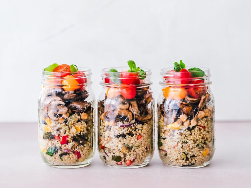 a group of glass containers with colorful fruit inside