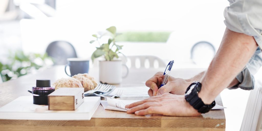 a close-up of a person writing on a piece of paper
