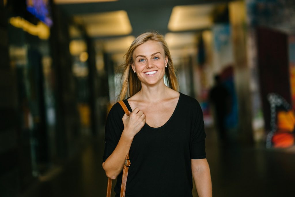 a woman smiling and holding a microphone