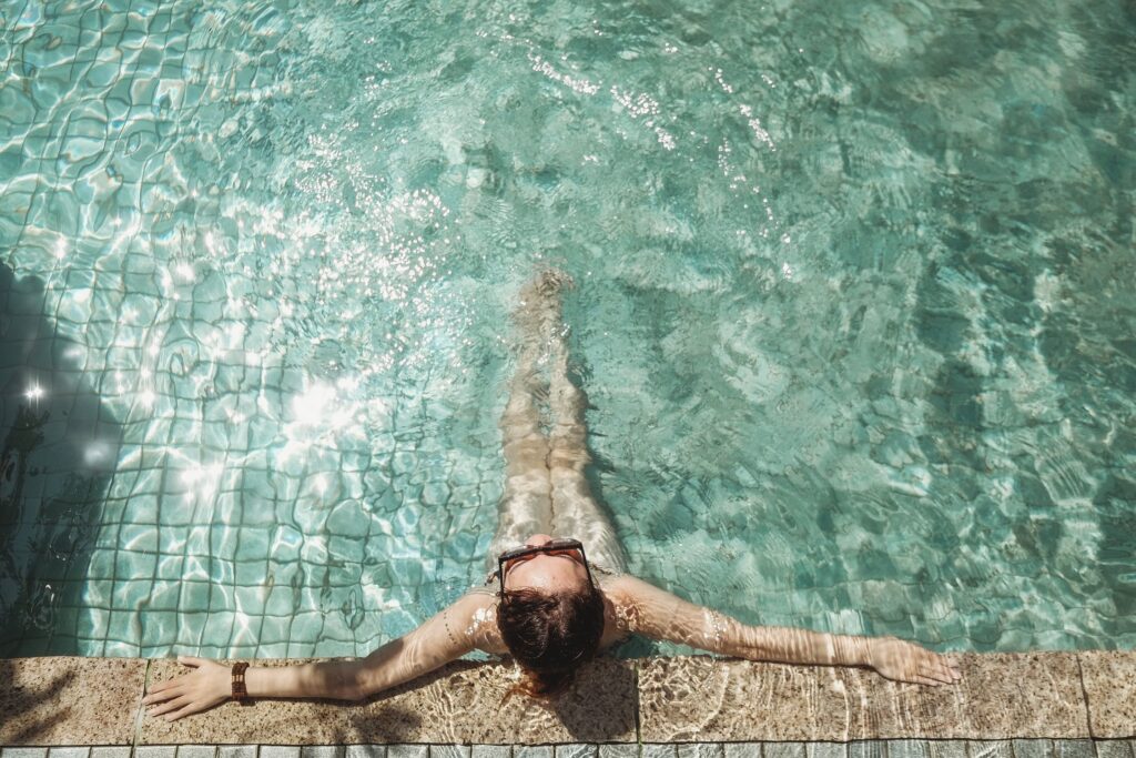 a person lying on a hammock in a pool