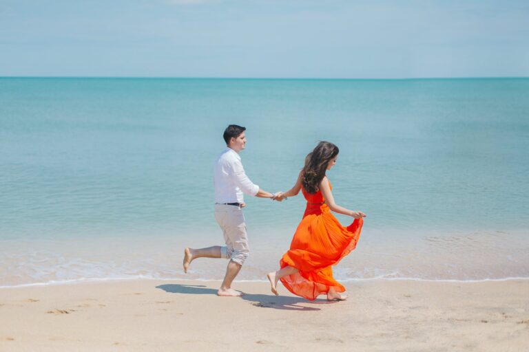 a man and woman dancing on a beach