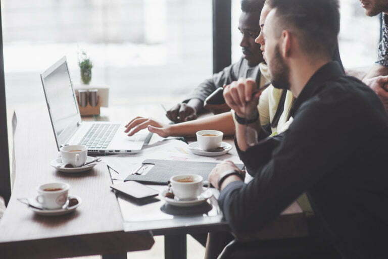 a person sitting at a table with a laptop and coffee